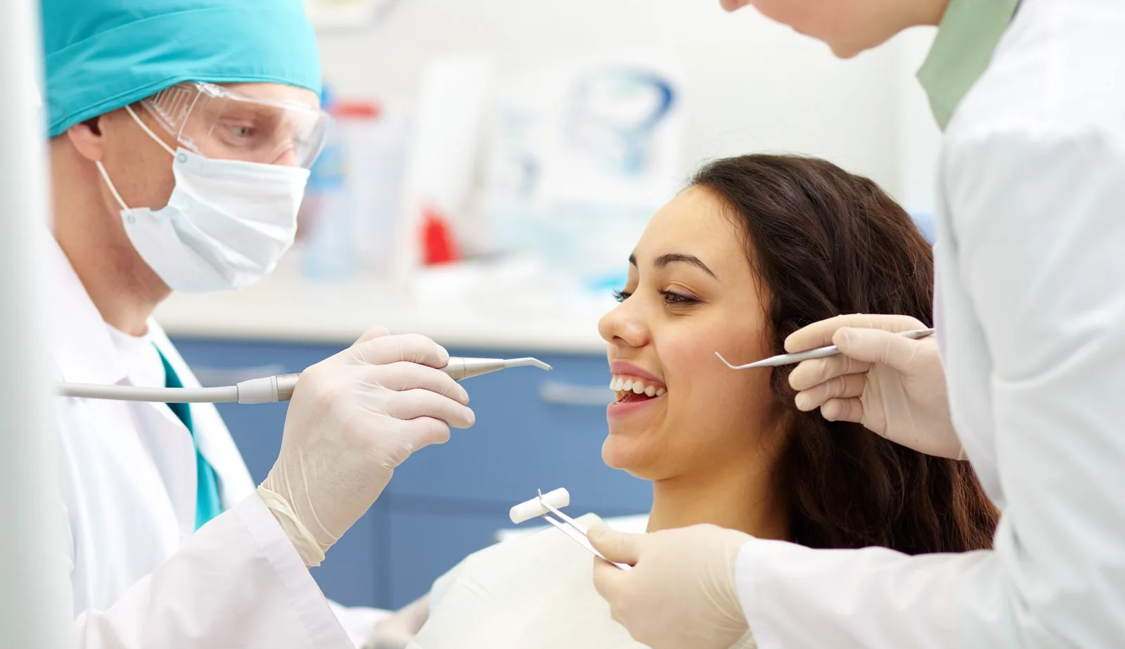 Dentista examinando os dentes de uma paciente com espelho odontológico.