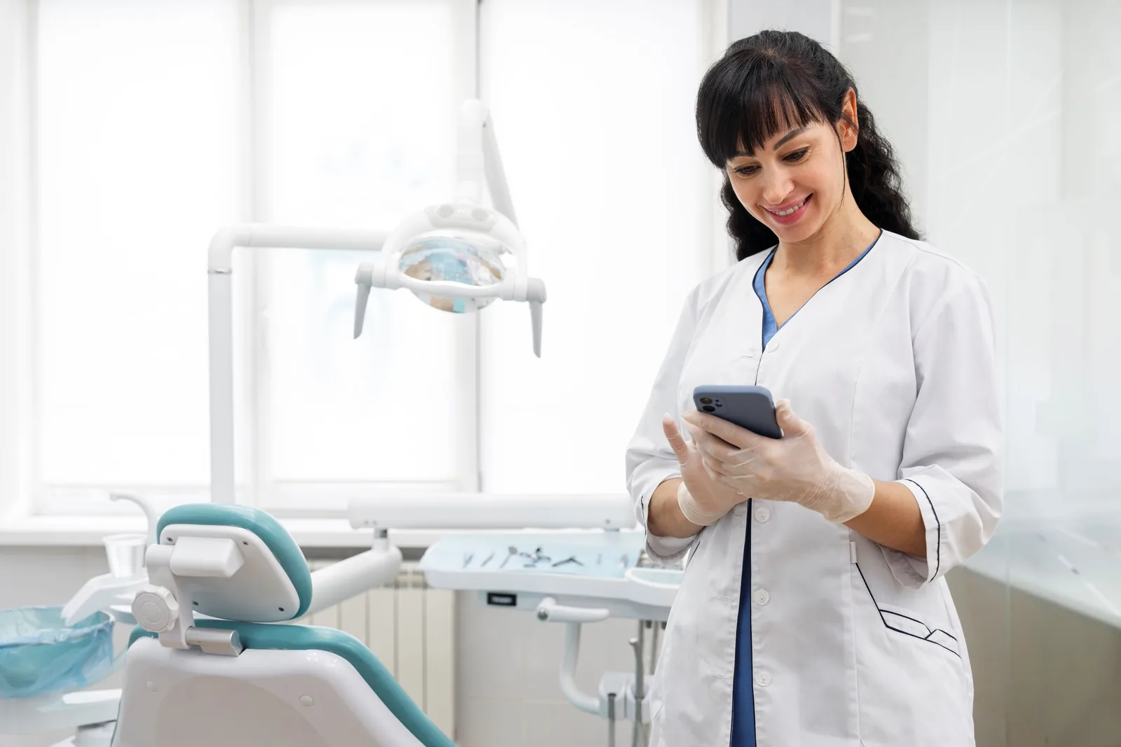 Dentista usando o celular no consultório.