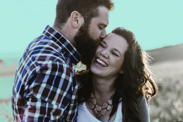 Casal sorrindo e se abraçando.
