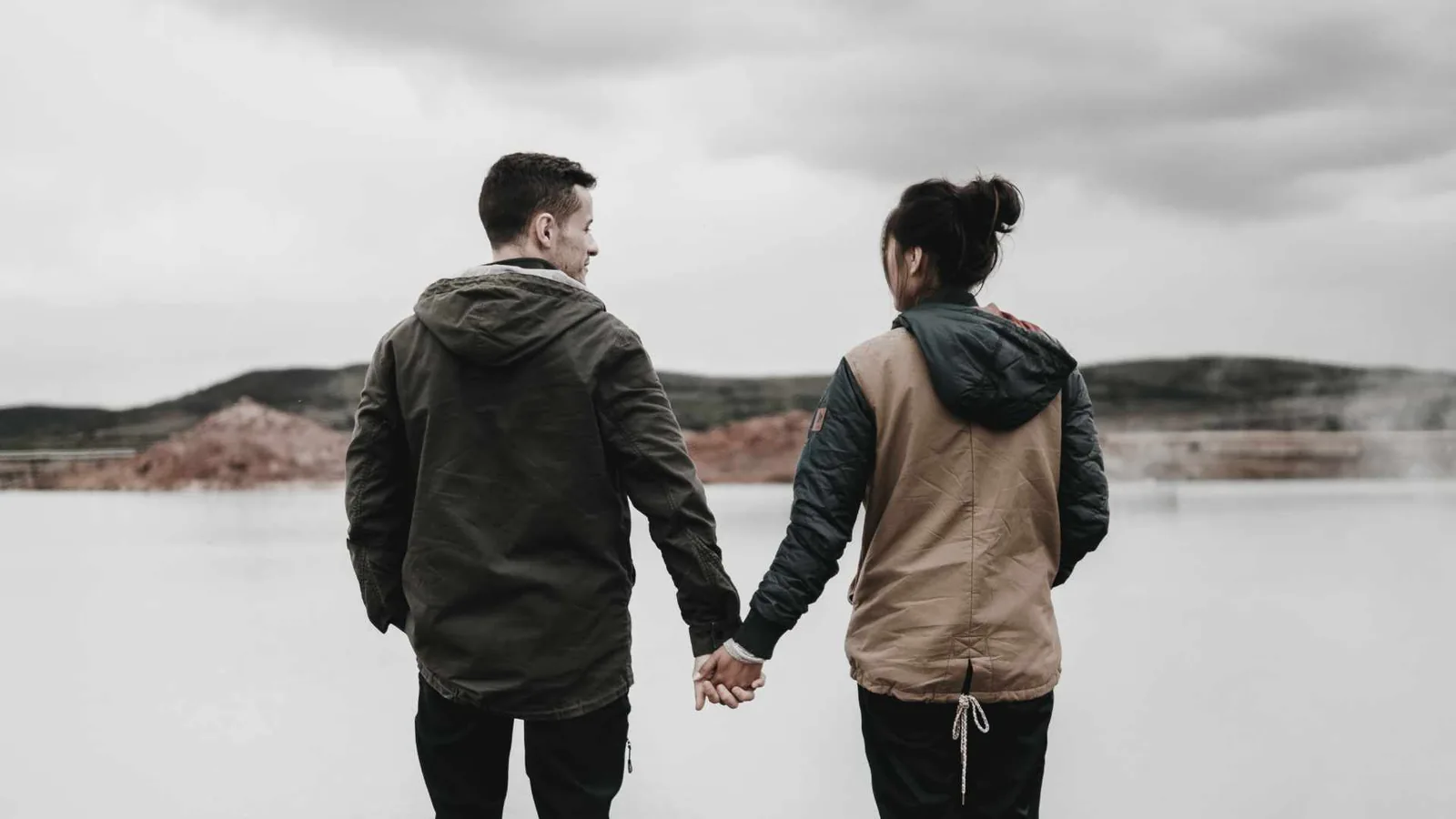 Casal caminhando de mãos dadas.