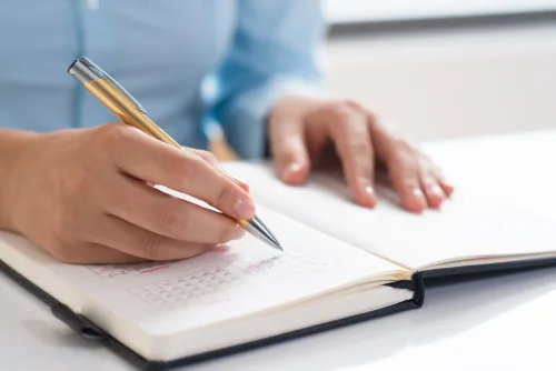 Profissional preenchendo uma agenda de consultas.