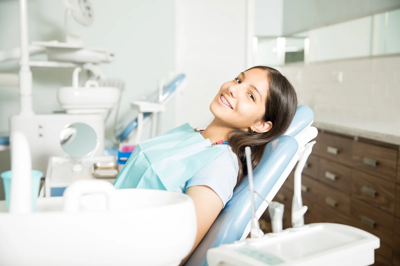 Paciente sorrindo na cadeira odontológica.