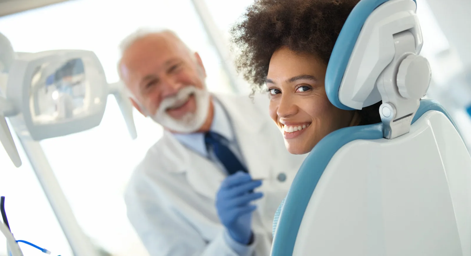 Paciente sorrindo durante atendimento odontológico.