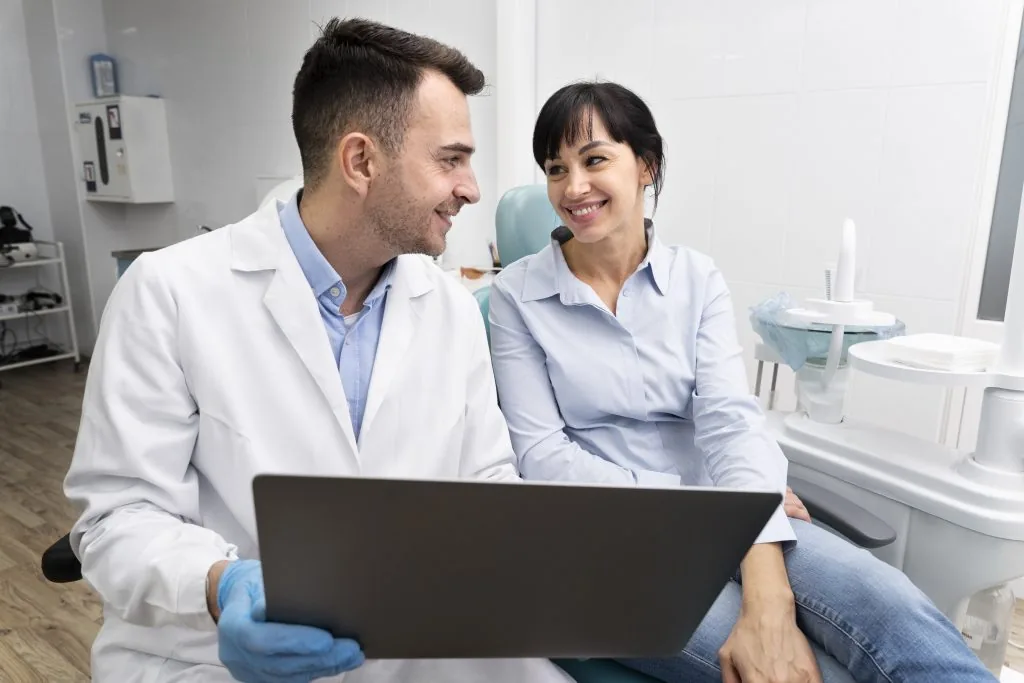Dentistas trabalhando em um notebook no consultório.