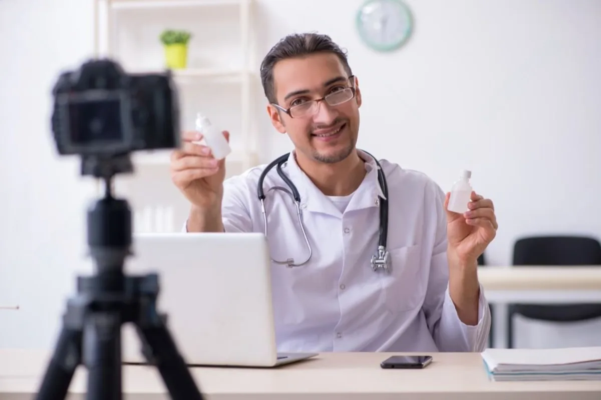 Médico gravando um vídeo diante de uma câmera.