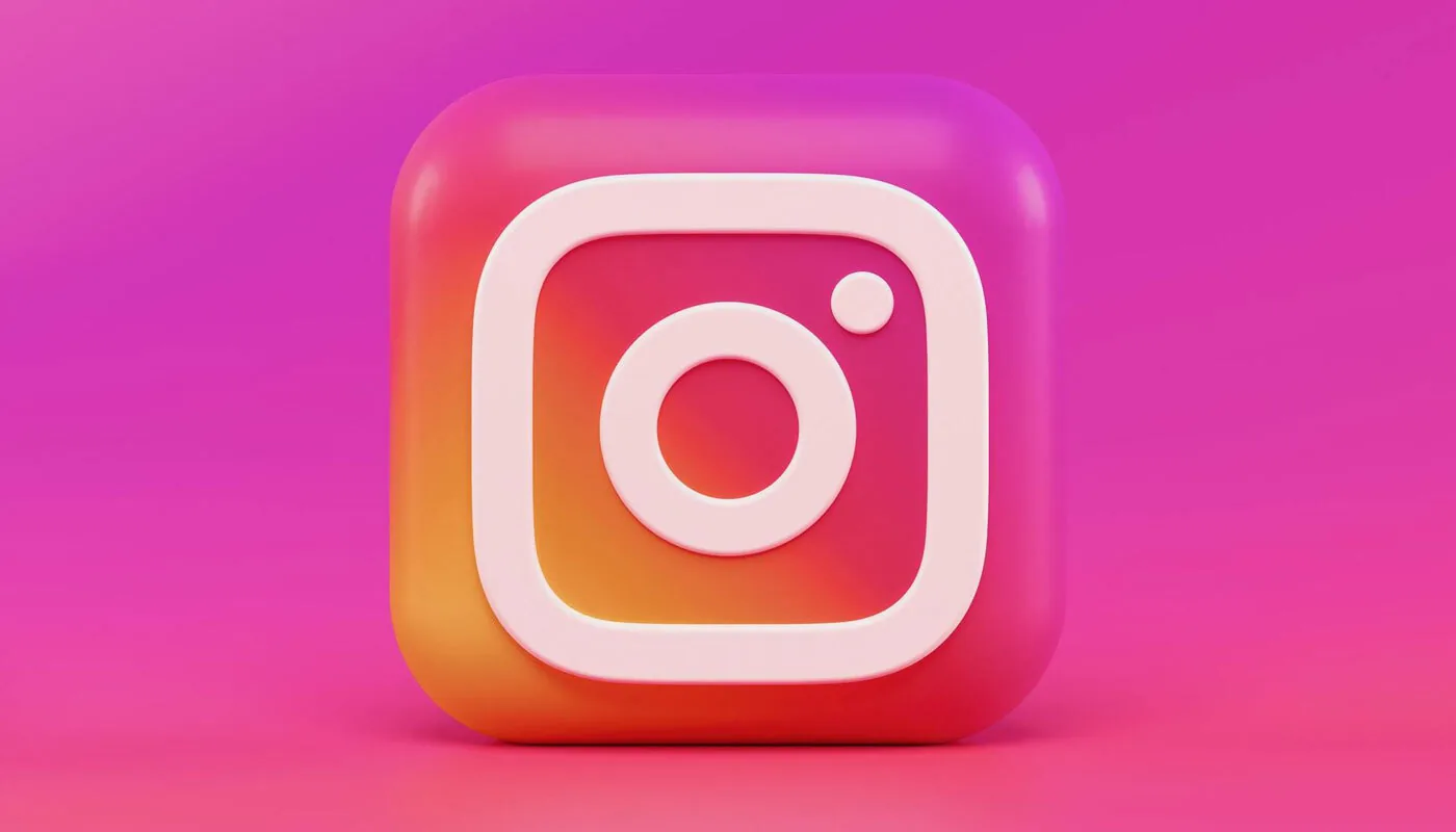 Ícone tridimensional do Instagram em fundo rosa.