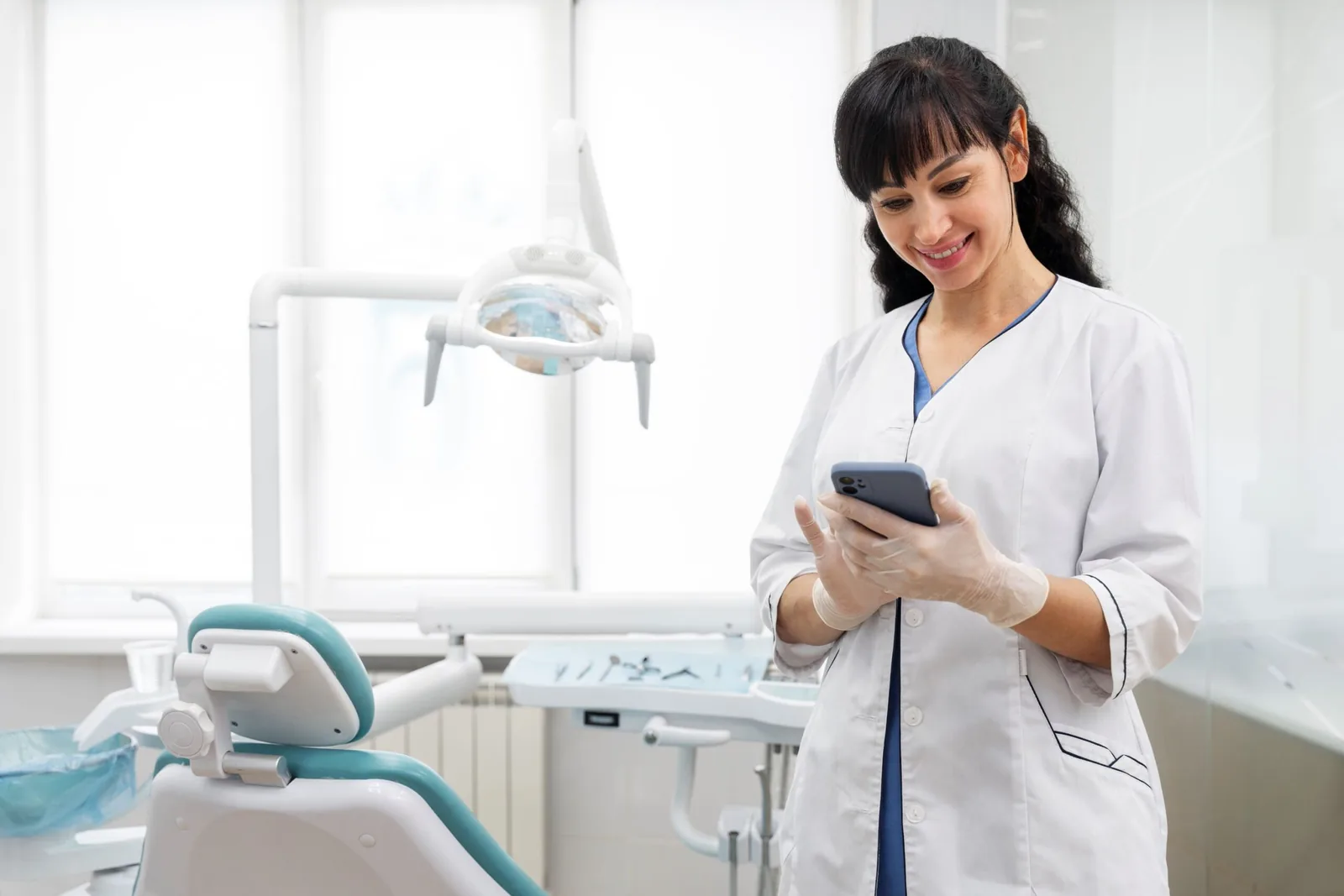 Dentista usando o celular no consultório.