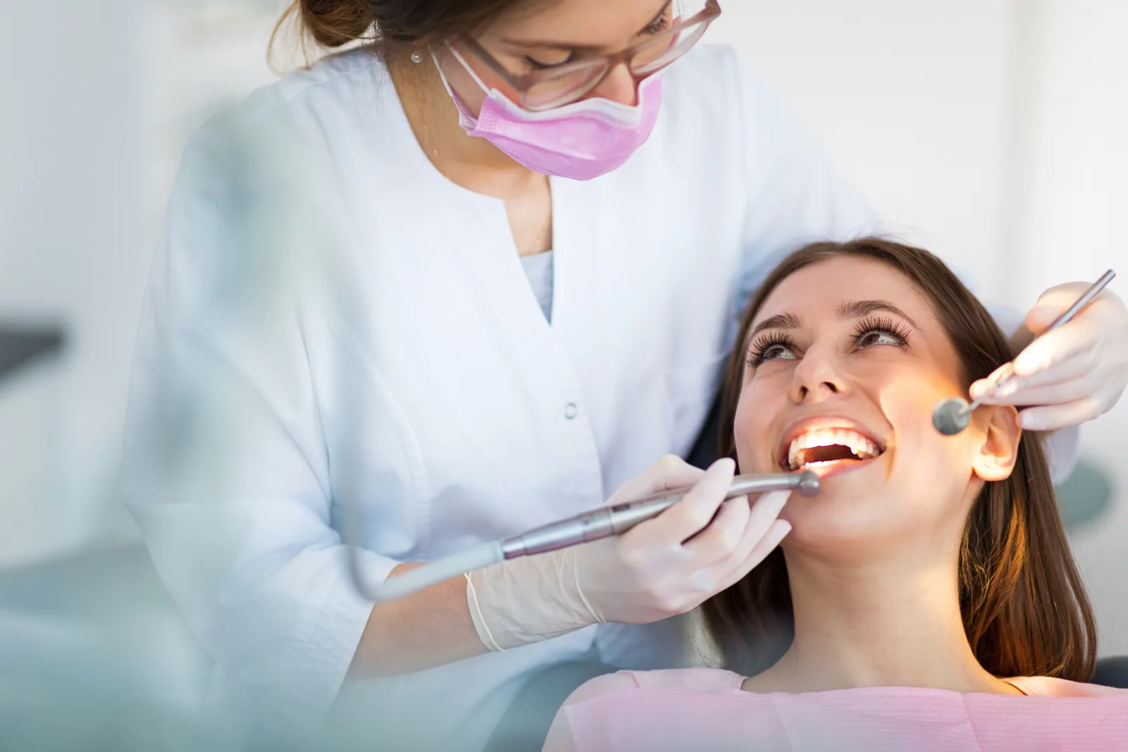 Dentista examinando os dentes de uma paciente.